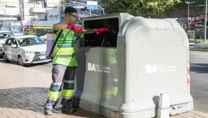 Operario de higiene urbana trabaja sobre un contenedor de residuos en la Ciudad de Buenos Aires